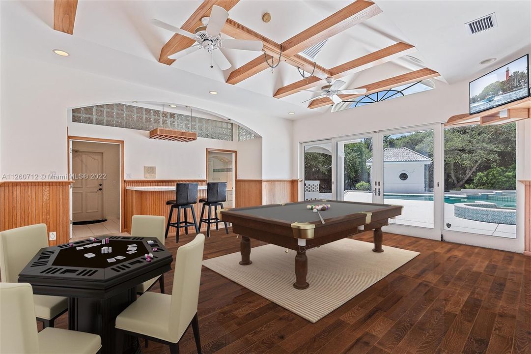 virtually staged club room with wet bar and pool views.