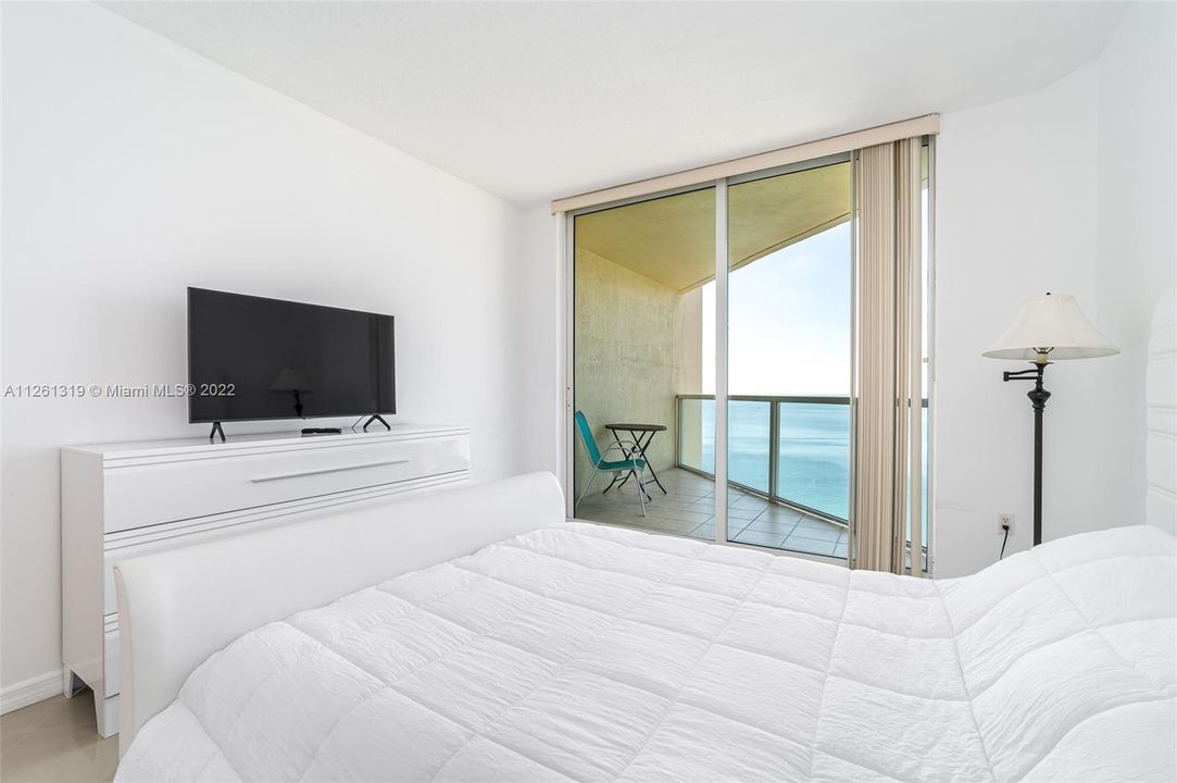Second bedroom with private balcony, ocean views, on-suite bathroom, and walk in closet