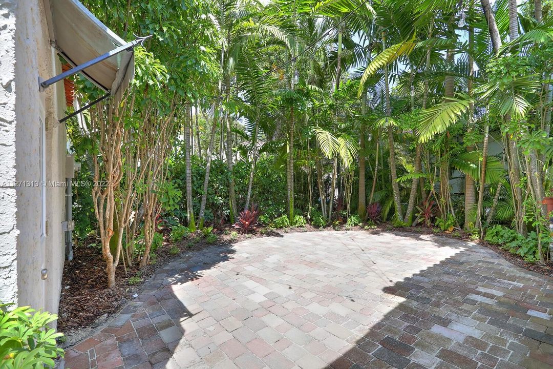 Nicely paved patio area surrounded by tropical landscaping creates a quaint atmosphere for social gatherings.