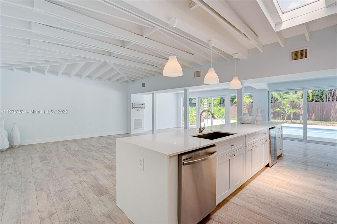 Open floor plan with wood beam ceilings, sky light and sliding doors for indoor outdoor living