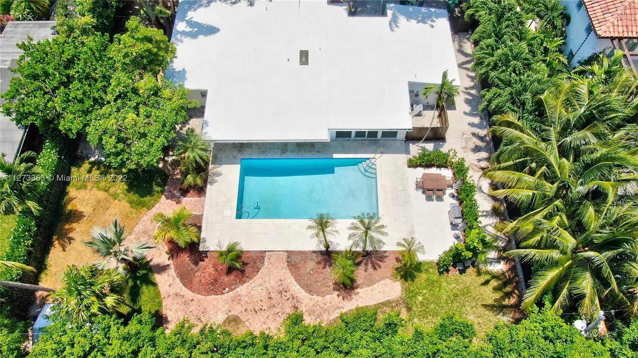 Aerial view of this private oasis on 12,000 SF lot. Fenced, freshly landscaped with oversize pool, outdoor shower, patio and bar b q. Ideal indoor/outdoor living. Perfect for entertaining.