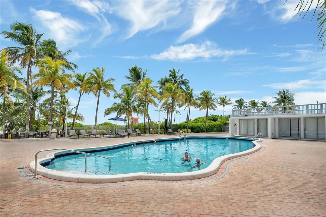 Free form pool just steps from the beach with surrounding cabanas