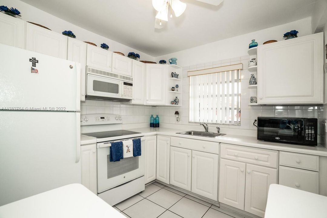Open kitchen w/view of pool area.  Appliances in excellent working order.  Mounted microwave is a convention oven as well.  Both microwaves can stay and are in like-new condition.  Pots and pans can stay.