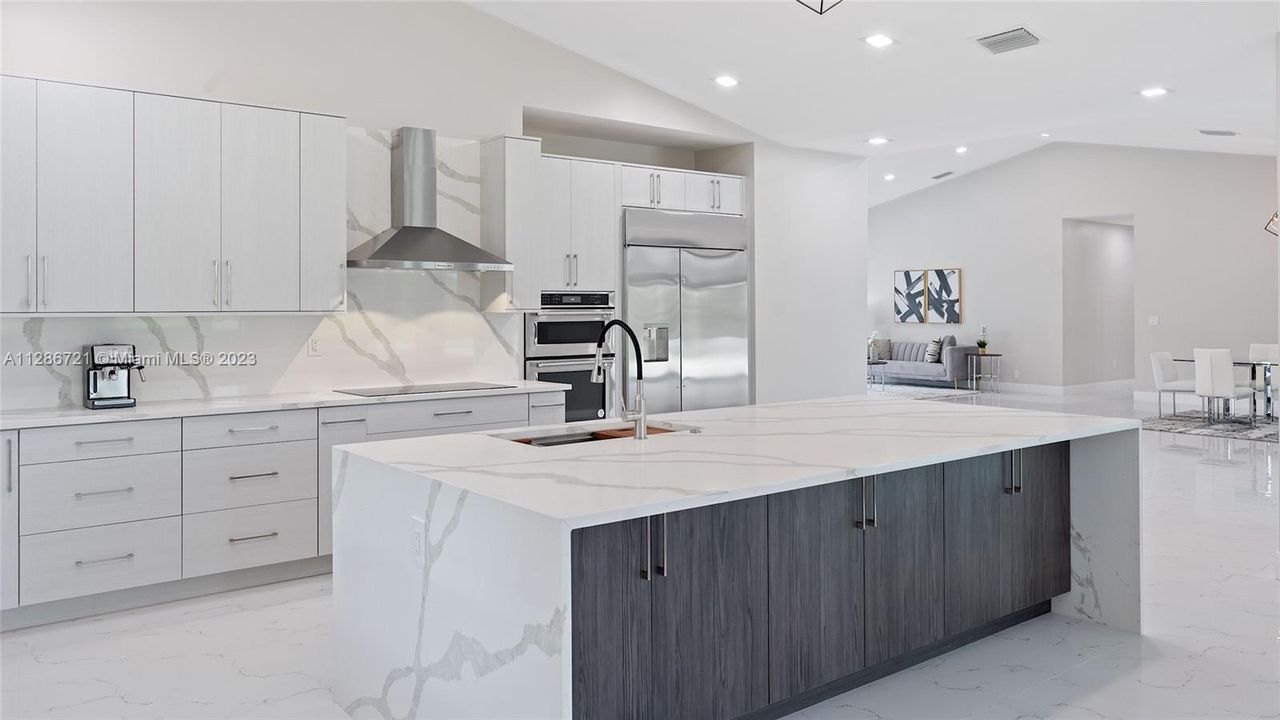 Custom cabinets with lots or drawers and a huge island with storage.  Quartz countertops, Kitchen Aid appliances and oversized Monogram refrigerator.