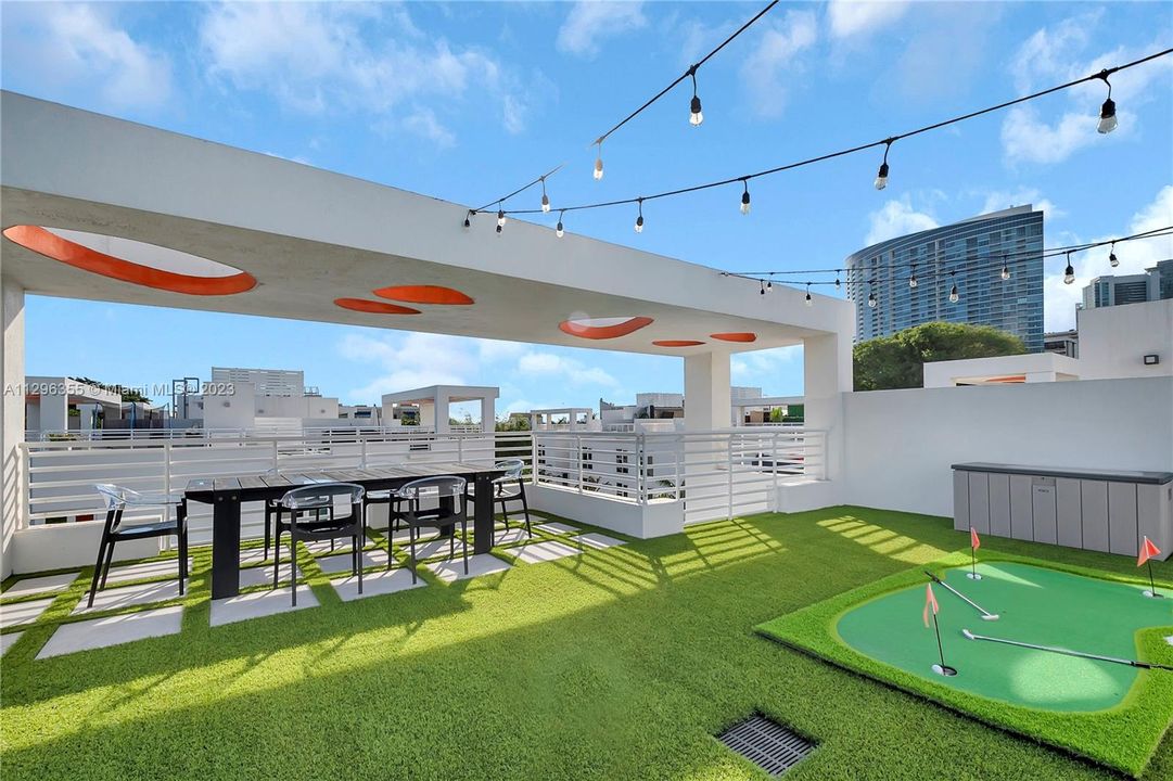 Amazing, turfed 1500sf private rooftop terrace with putting green, dining table, and corn hole