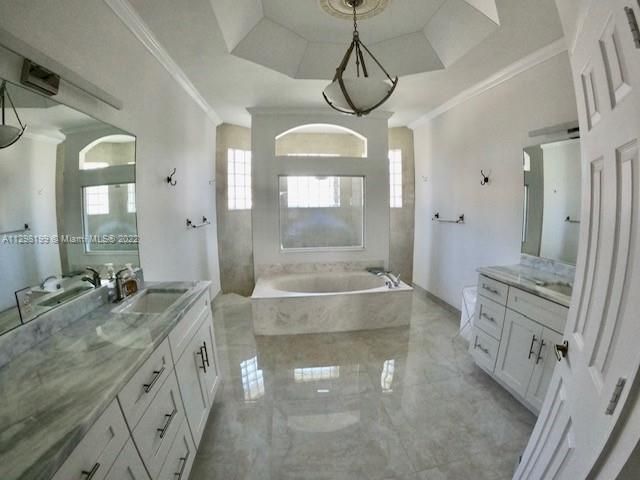 Master bathroom with dual sinks, linen closet, tub and shower