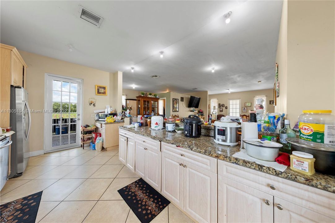 large counter~opens to one of many covered terrace, nice wood cabinetry and marble counters