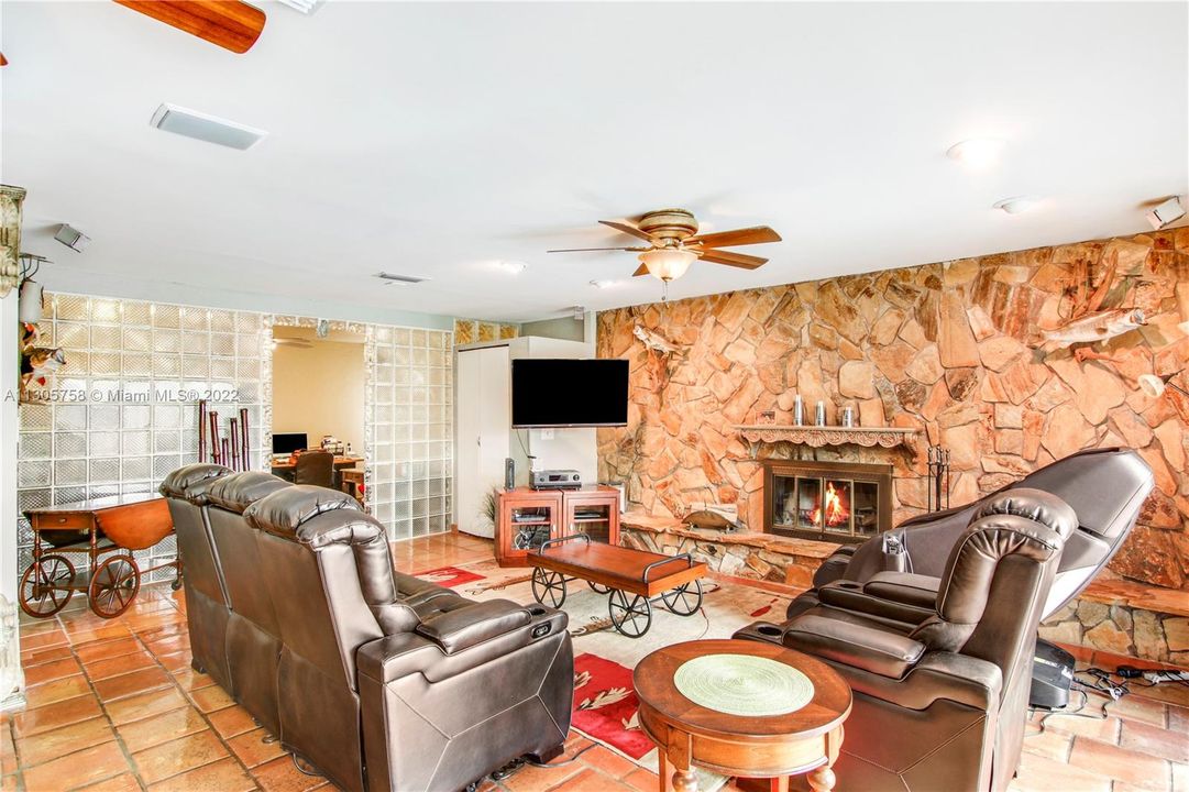 Stone wall and fireplace make this room cozy and inviting.