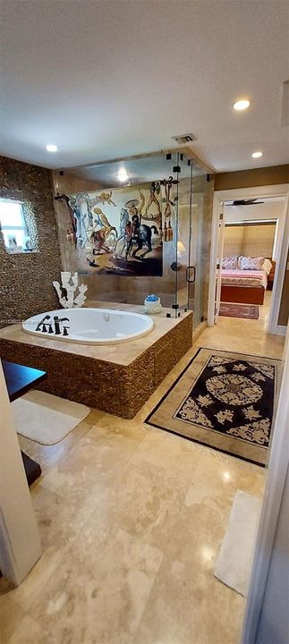 jacuzzi tub, double shower glass enclosed, stone floors. rock walls