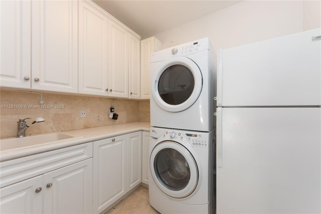 LAUNDRY WITH SINK, CABINETS AND REFRIGERATOR.