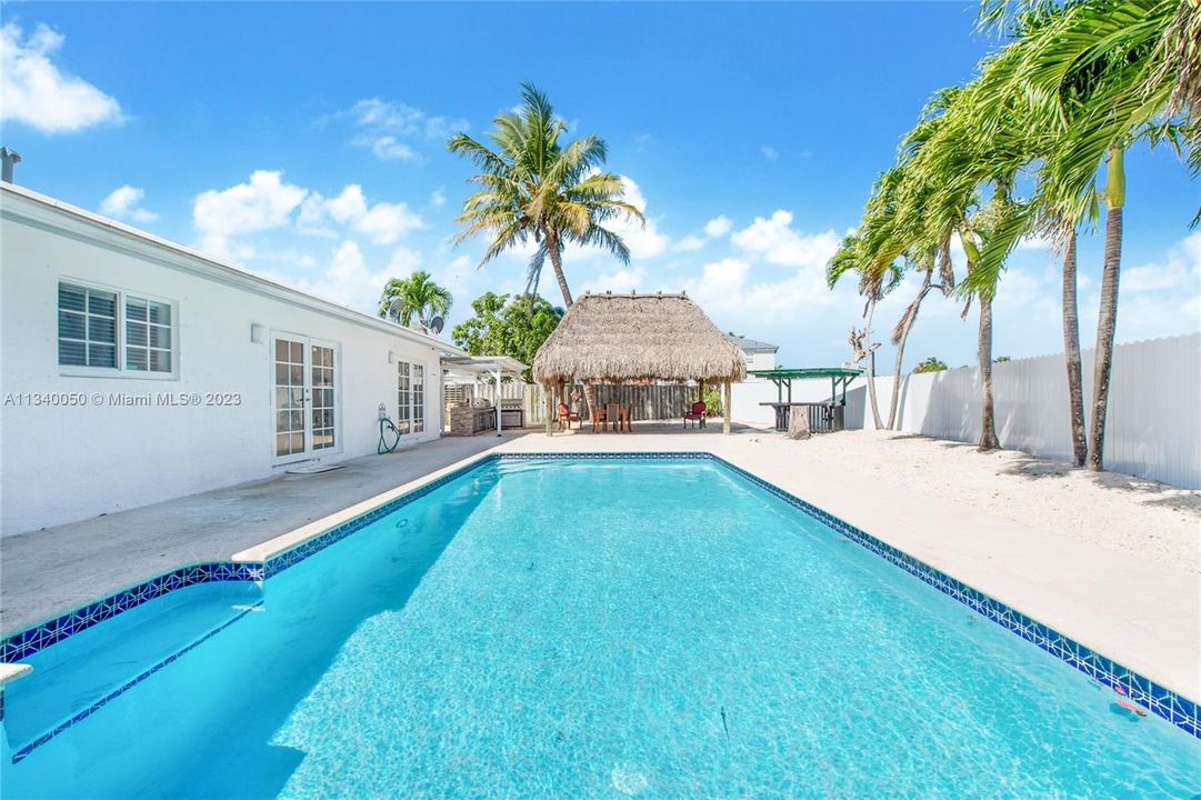 Newly resurfaced sparkling pool with outdoor kitchen and chickee hut
