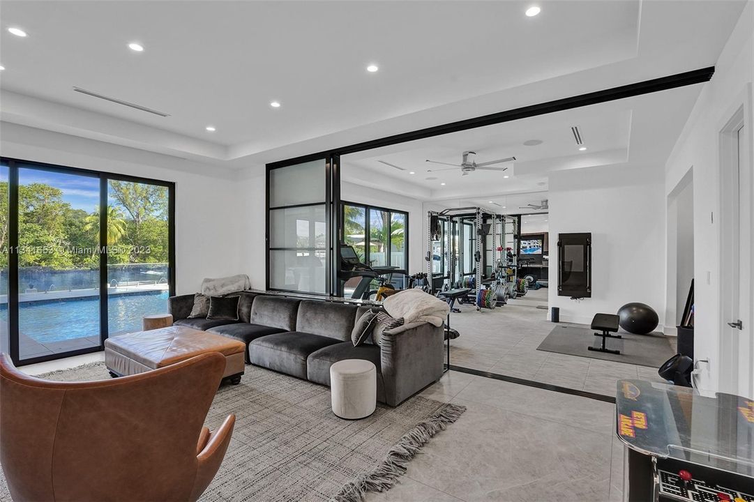 Main level living room adjacent to the main living space and gym