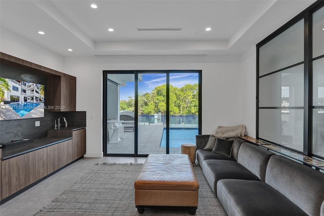 Main level living room adjacent to the main living space and gym