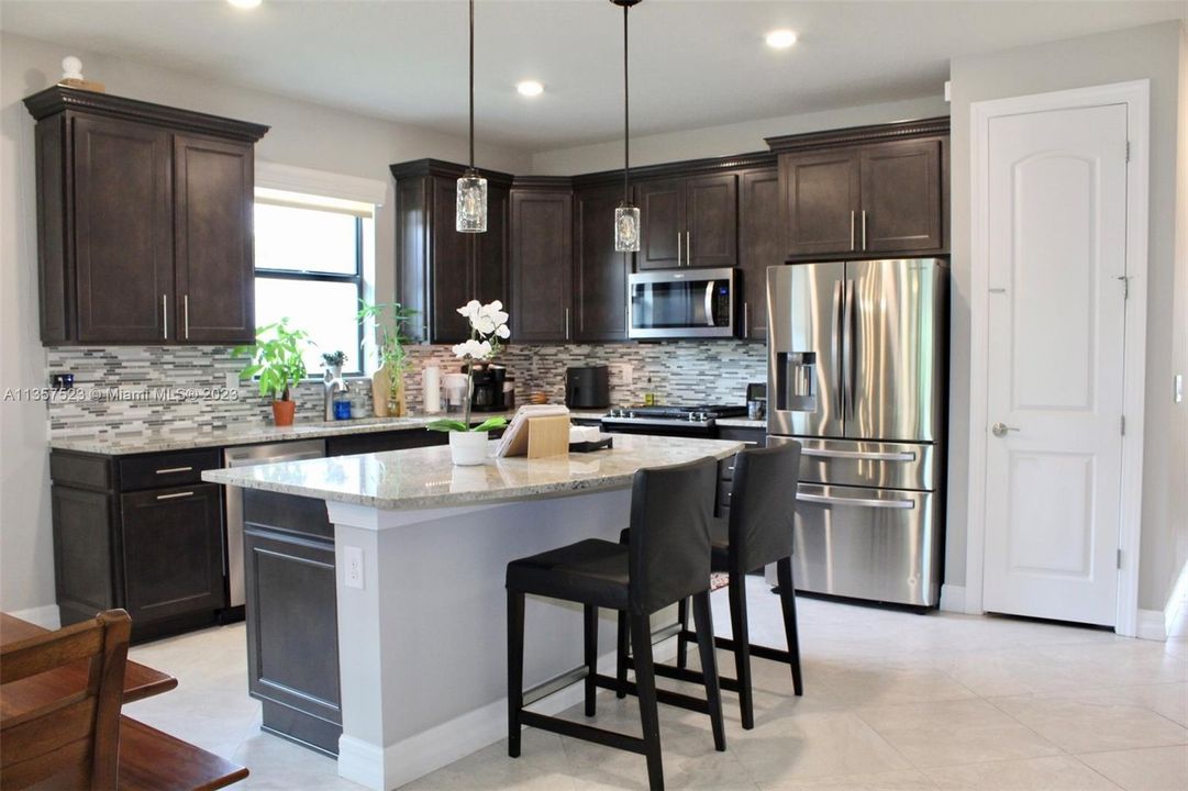 Kitchen with quartz countertops, stainless steel appliances and pantry