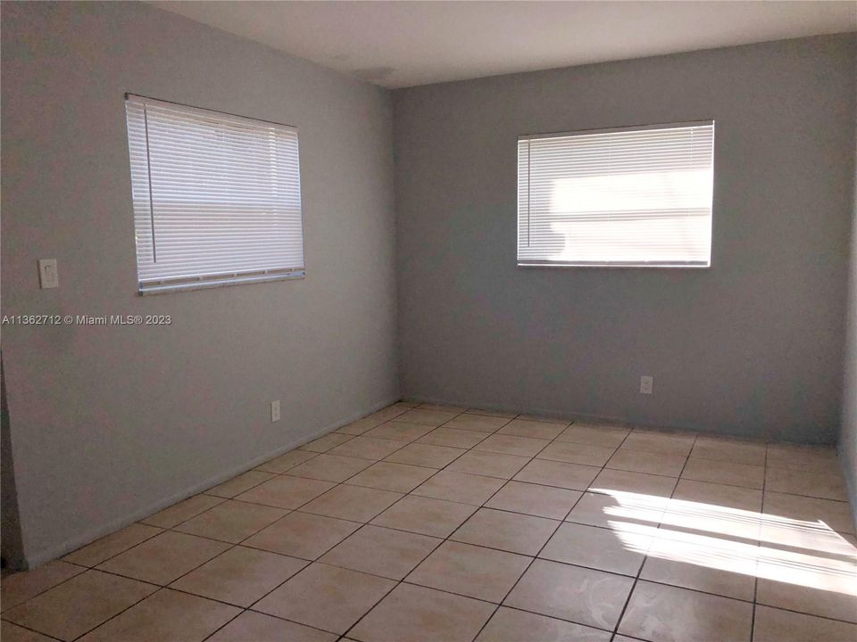 The bedroom features a window to the side of the property and one to the back.