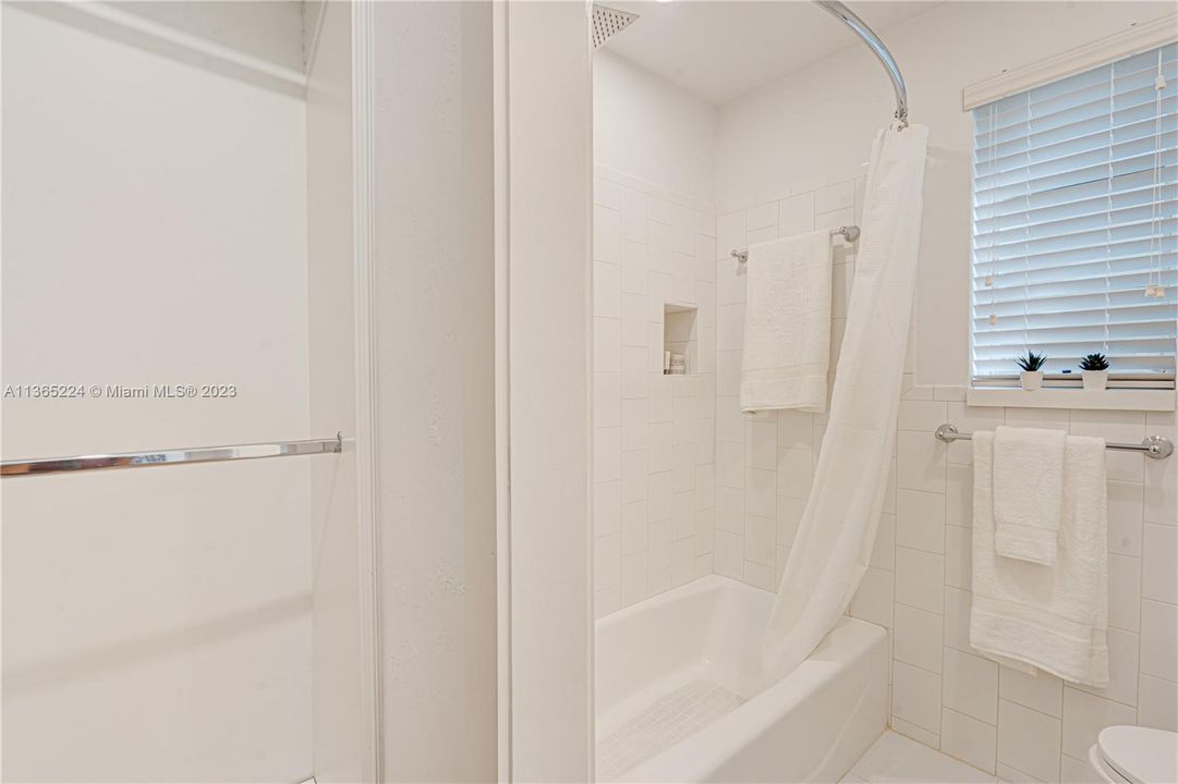 Shower/Tub in classic beautiful white tile throughout