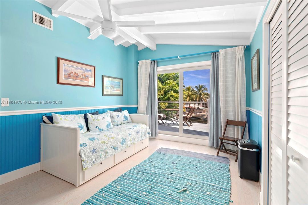 3rd bedroom of 4 bedrooms is a real treat with sliding impact doors to a sun deck overlooking the back yard entertainment area, pool and water.