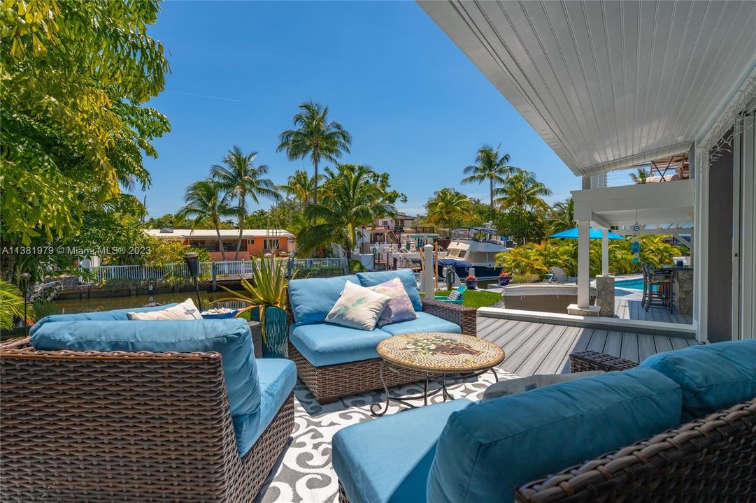 Raised patio/deck outdoor and semi-covered seating area just off the Florida Room & Living Room overlooking the the water and the fire pit.