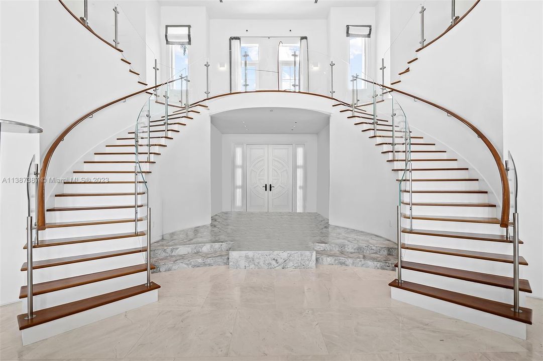 Grand Entry from double front doors with 2 staircases leading upstairs to east facing balcony and Master Suite on the right and North Wing Bedrooms on the left.