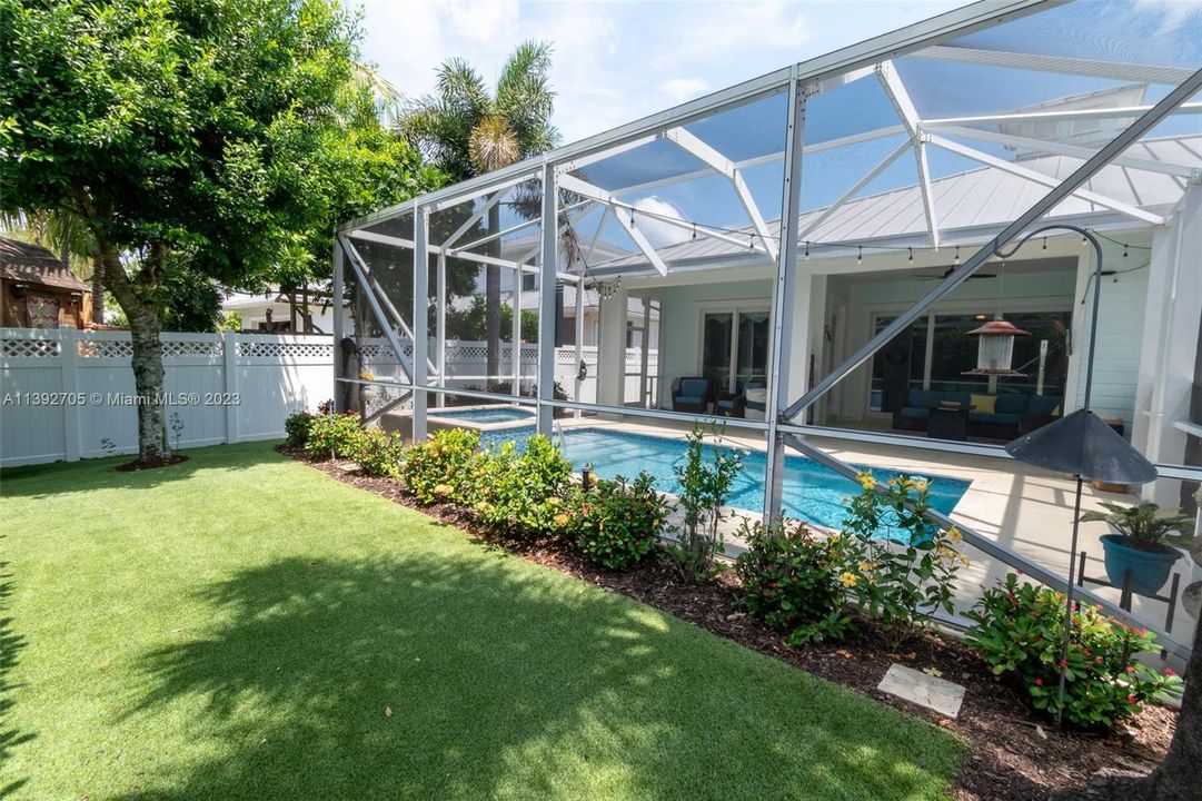 Gated backyard area with screened in patio