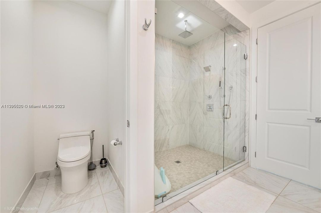Main bathroom: private toilet area with door and large upgraded shower