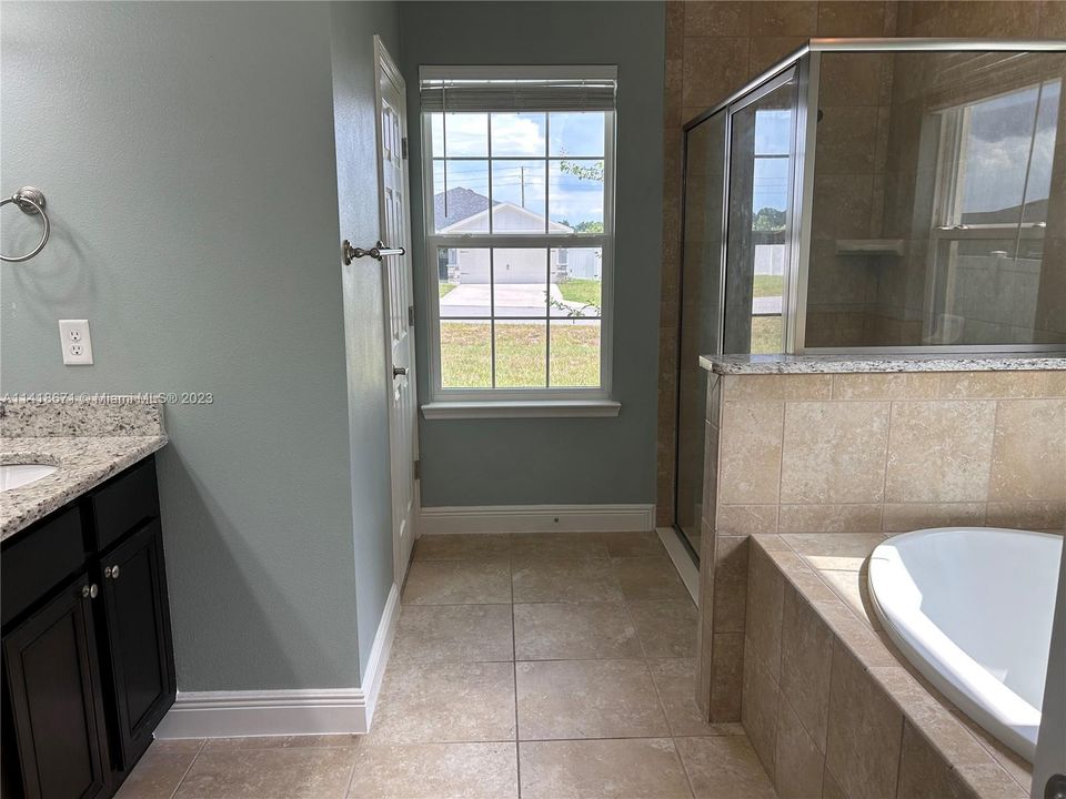 Master bathroom with double sink vanity, tub, shower and water closet