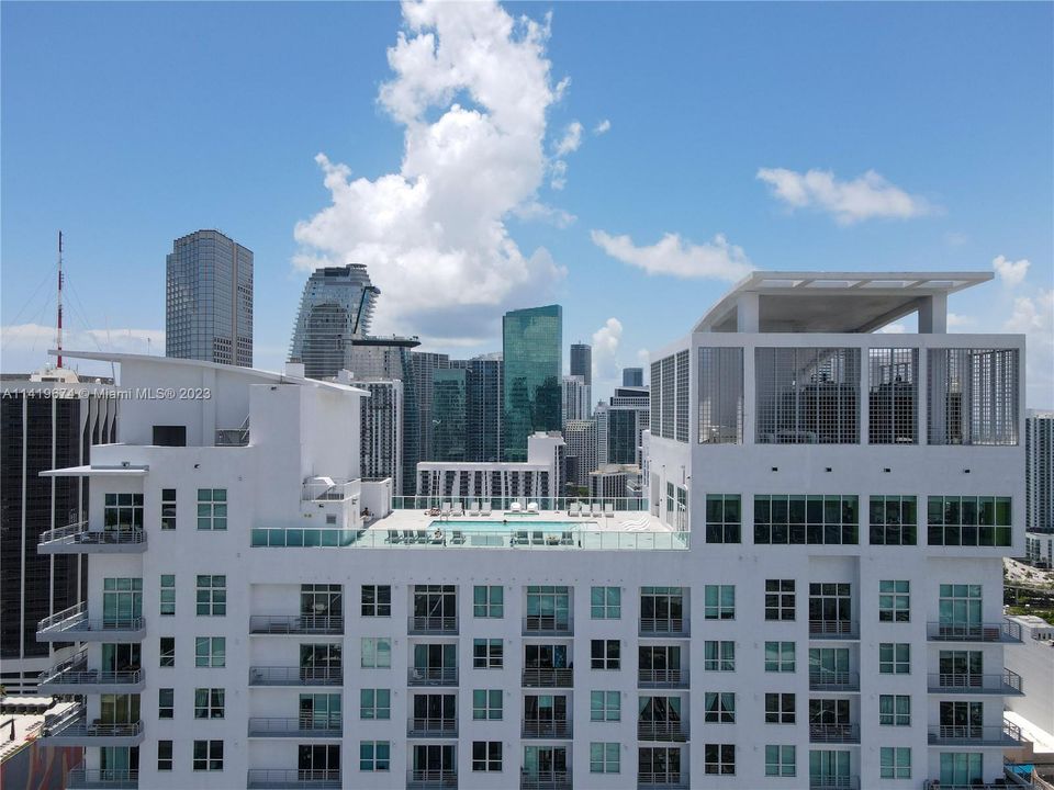 Aerial View looking South. Rooftop Pool and Jacuzzi at center. Fitness Center all glass area on top right.