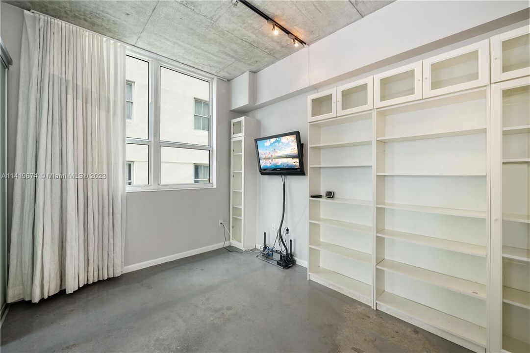 Second bedroom with wall of shelves