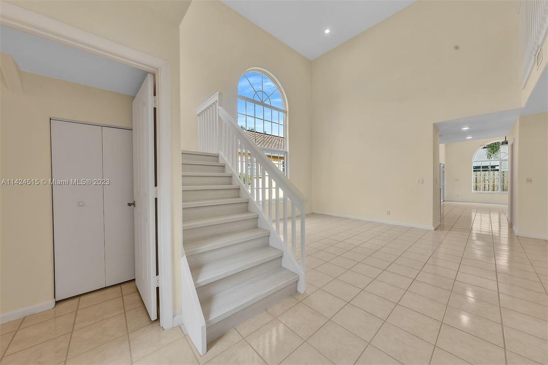 Spacious storage under stairs in powder room.