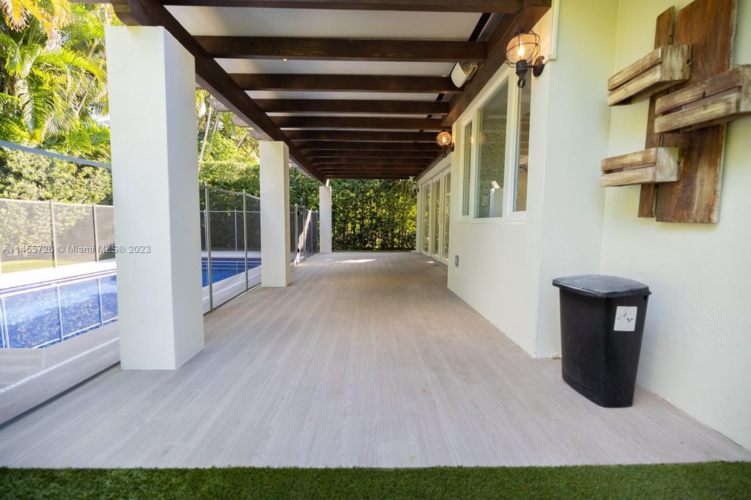 Covered patio with lighting over looking the pool