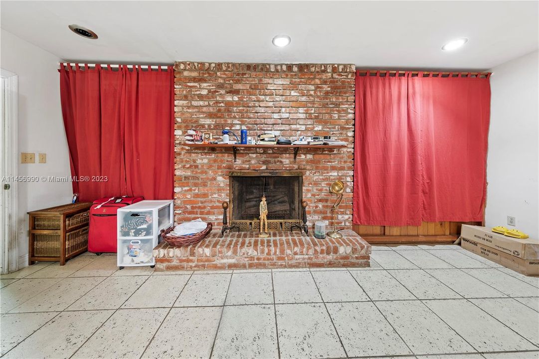 FAMILY ROOM WITH BUILT IN WOOD SHELVES (BEHIND THE RED DRAPES) IS AN ENORMOUS SPACE. IT OPENS INTO THE GARAGE AREA LOCATED NEAR THE KITCHEN. THIS HOME IS A SLEEPER WITH SO MANY OPTIONS