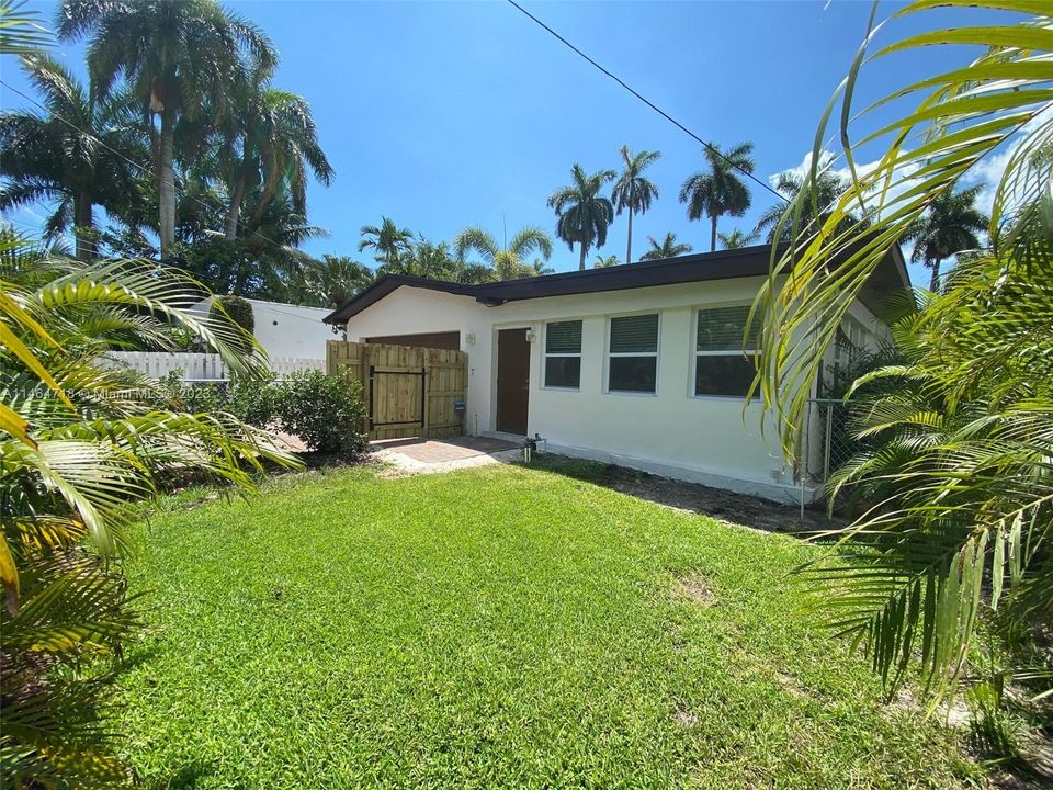 Backyard with access to the driveway and garage