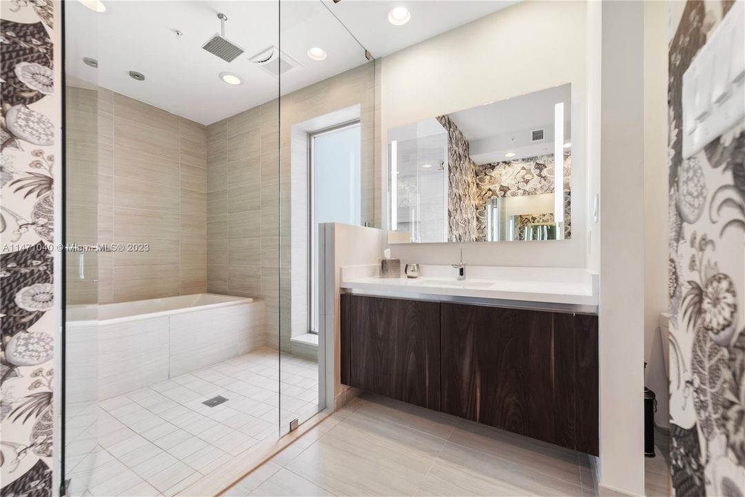 Primary Bathroom with Glass Enclosed Shower + Tub & 2 Backlit Vanities