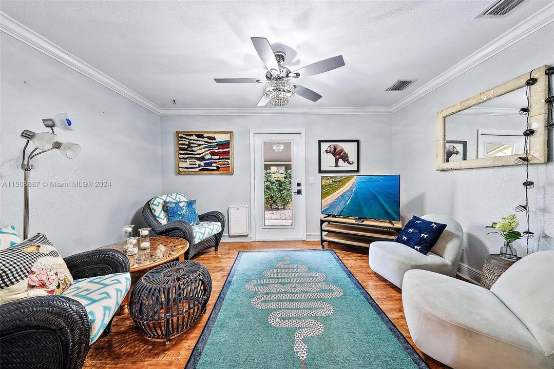 Wood flooring. Walk out impact glass door to side patio and yard.