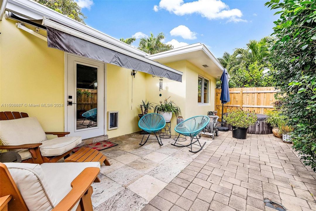Covered stone paver patio with retractable awning in fully fenced in yard. Fence installed August 2023.