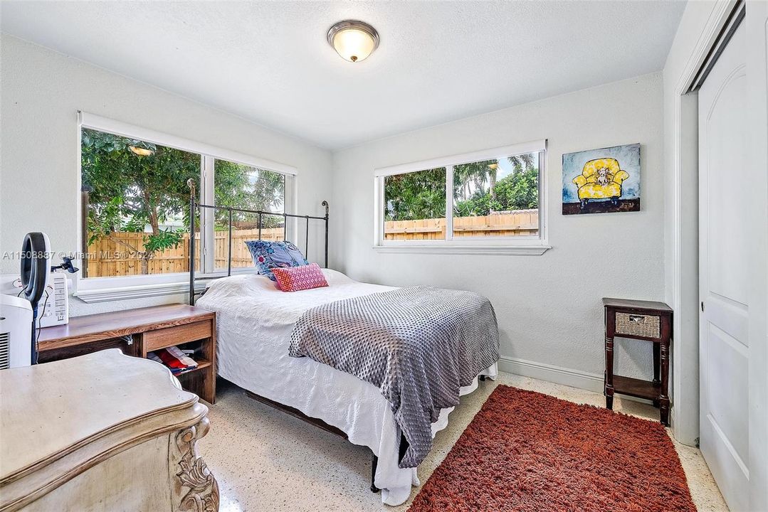 Bedroom with lots of light from impact windows. Terrazzo flooring.