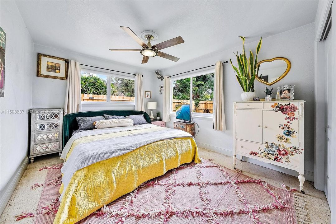 Primary bedroom with lots of light from impact windows. Terrazzo flooring.