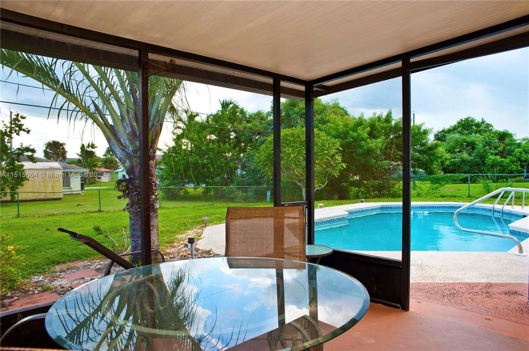 Screened Porch with Patio Furniture, Pool and Backyard View