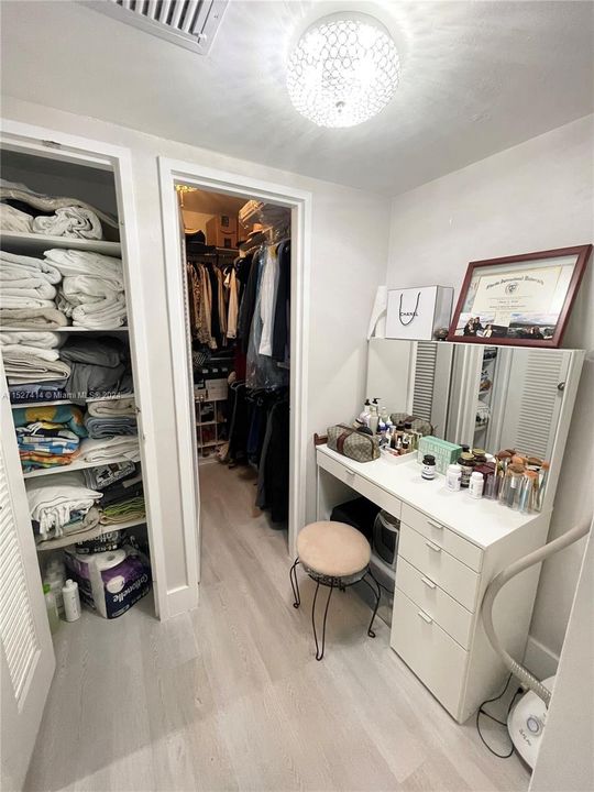 Dressing area leading to walk in closet and linen closet
