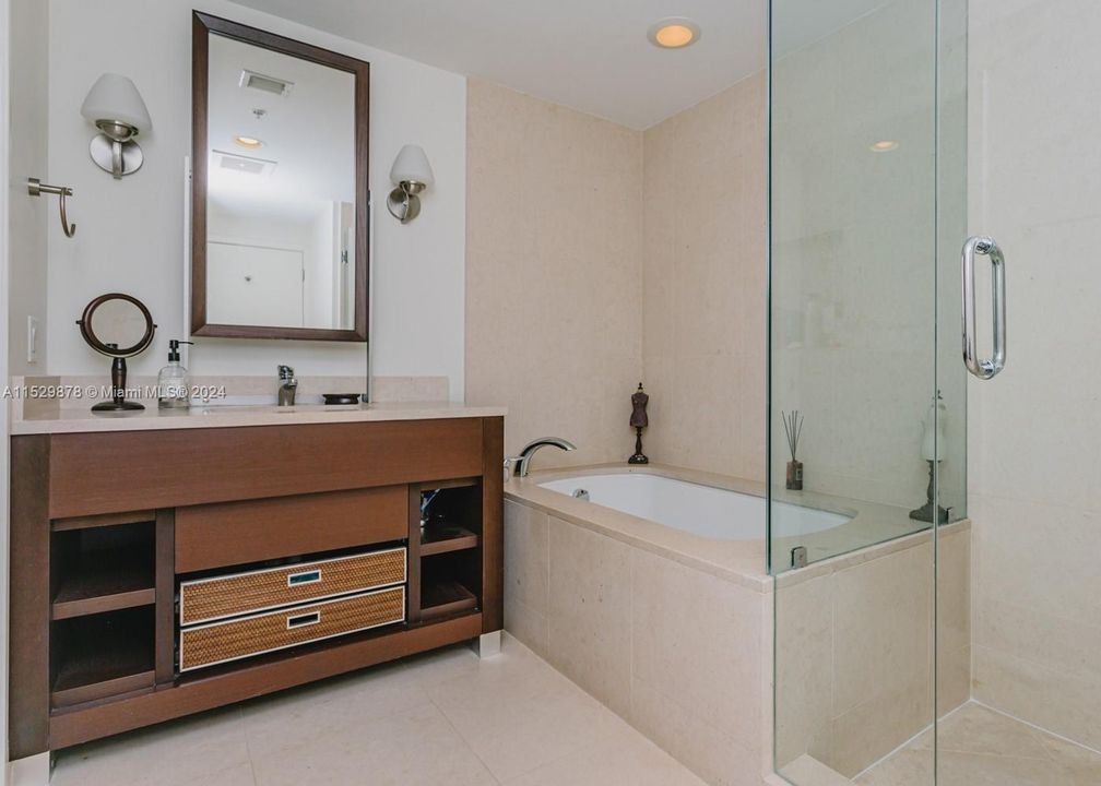 Vanity with single sink, tub, separate shower and private toilet with bidet set.