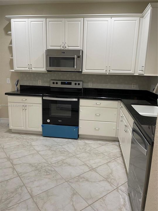 Beautiful black granite, tile backsplash, NEW touches faucet, dishwasher and range that overlooks open living area and patio.