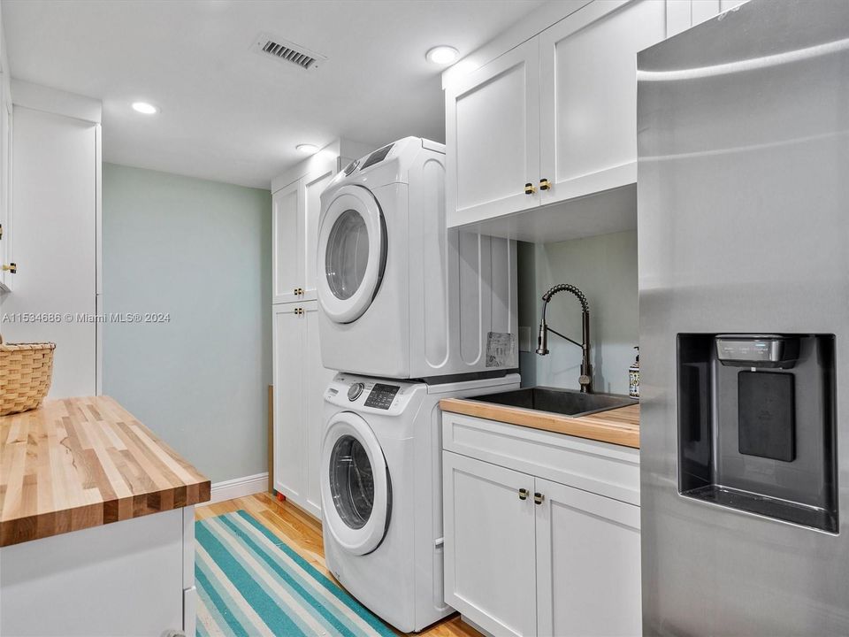 Laundry room with extra refrigerator and laundry sink.