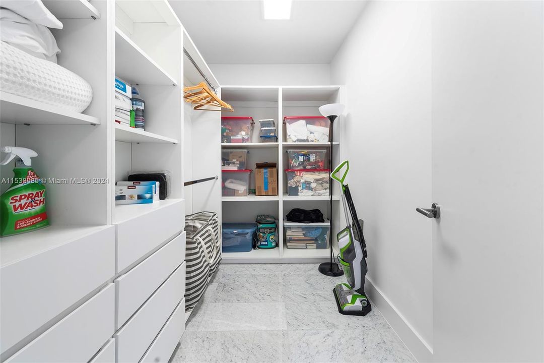 Secondary bedroom full walk-in closet with custom cabinetry