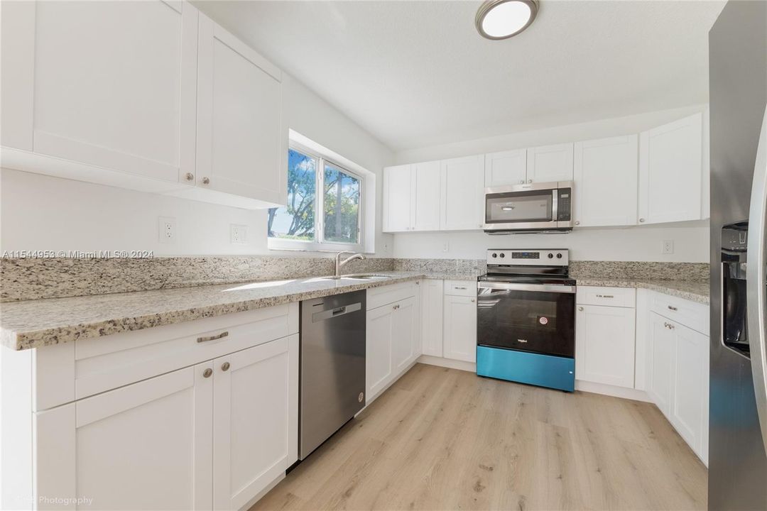 Brand NEW white, wood cabinets with granite countertops and Brand NEW Stainless Steel appliances.  The granite has a beautiful blend of natural colors to match any type of decor!