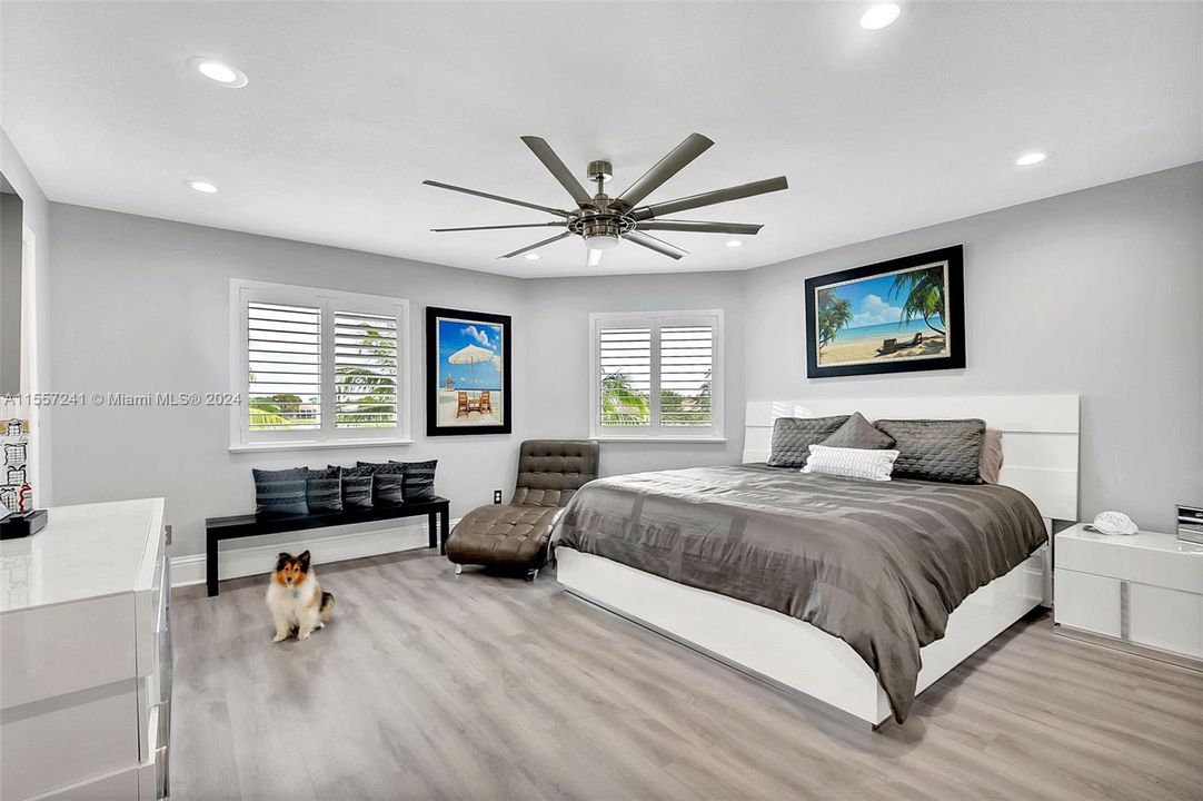 Master bedroom located on second floor with views of the lake. Finished interior includes Bahama Shutters. Also note engineered wood and gorgeous paddle fan!