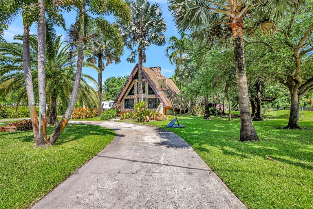 Large circular driveway and gorgeous mature trees on property