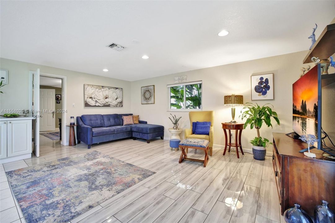 Plank tile flooring in living room of guest house. High hat ceiling lights