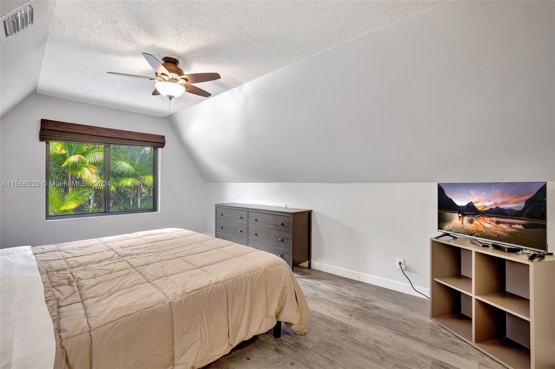 Primary bedroom upstairs w/ garden and pool view