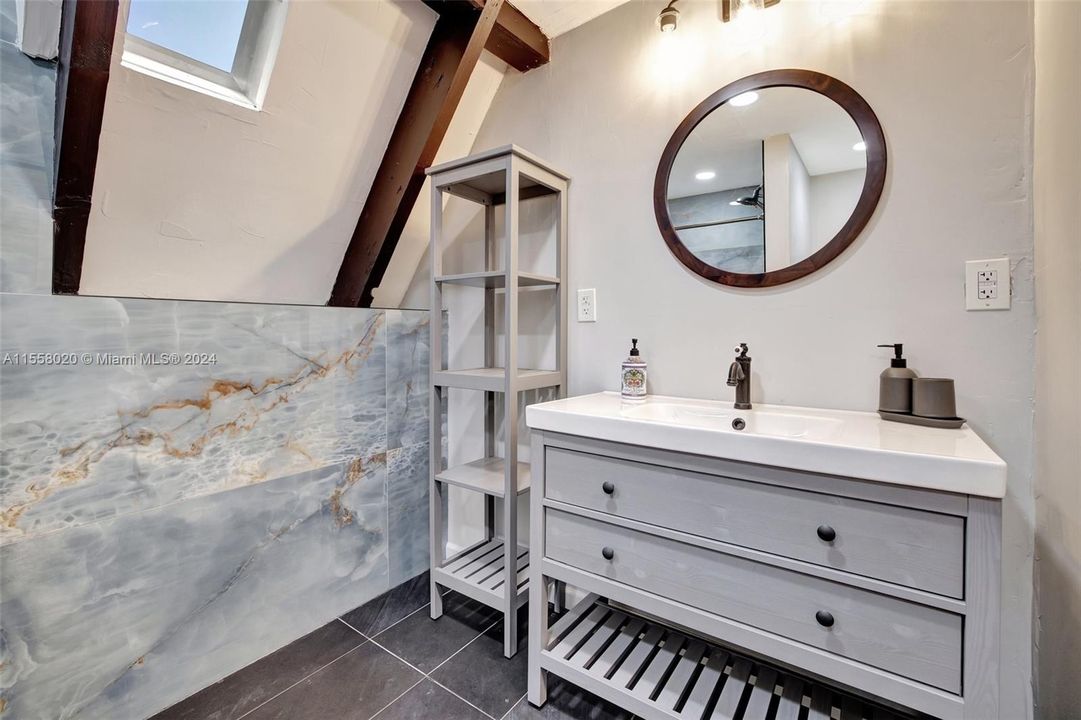 Beautiful flooring, new vanity and wall tile (looks like natural stone to continue the look of the property)