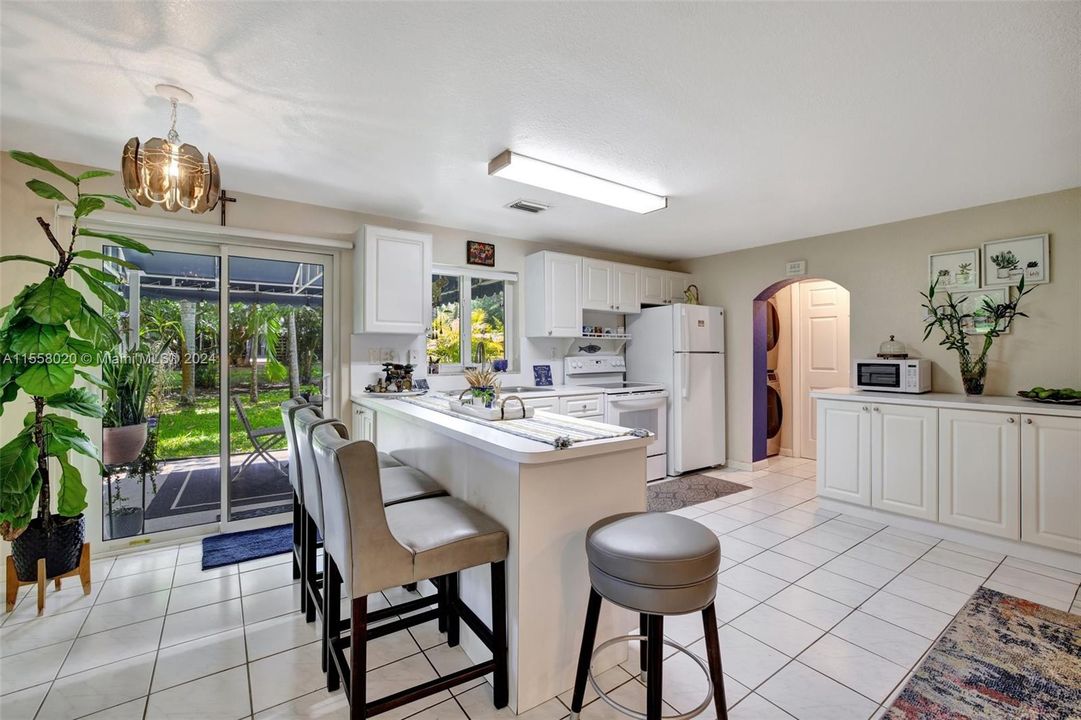 Sliding glass doors leading to private patio overlooking backyard. View toward laundry and bathroom to the right